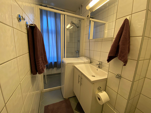 Baderom med varmekabler og vaskemaskin.